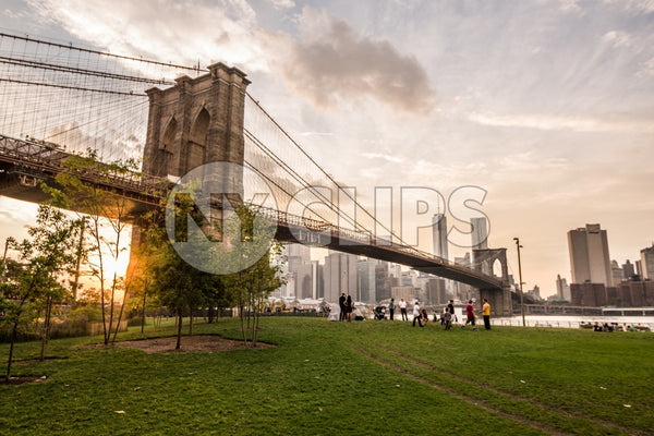people watching sunset and Manhattan skyline from Brooklyn Bridge Park in NYC