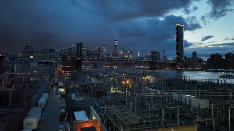 industrial Brooklyn view of bridge and Manhattan skyline at night in NYC