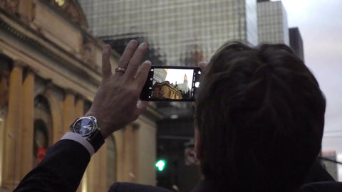 tourist man taking smartphone photo of Chrysler Building and Christmas wreath on holidays in Manhattan NYC