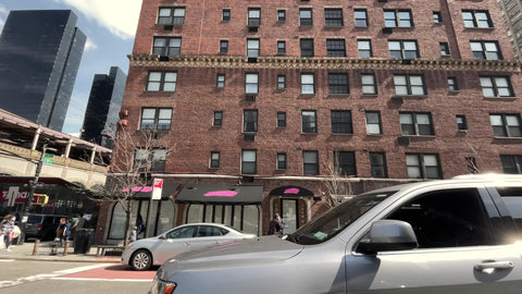 driving up ave past 59th street 1st Avenue passing tram and Queensboro Bridge in Manhattan New York City NYC