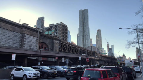 Brooklyn Bridge entrance on Lower East Side with parked cars and Beekman Tower on 8 Spruce Street Downtown Manhattan New York City NYC