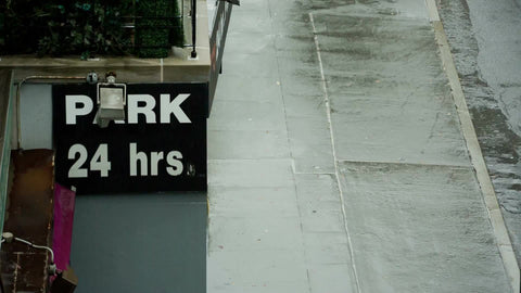 man walking past parking garage in rain with umbrella on rainy day in NYC