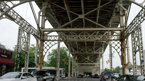 bus crossing 125th Street in Harlem under elevated subway train tracks