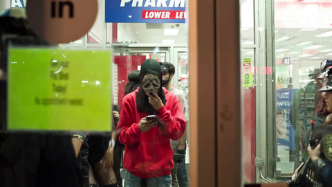 man in Scream mask inside store at Halloween parade in Greenwich Village