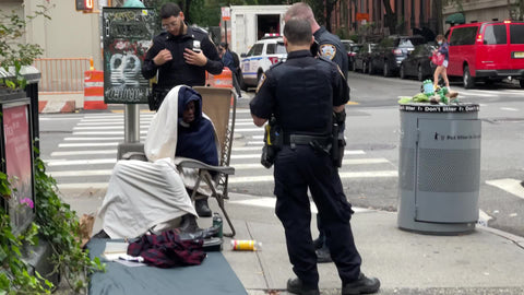 NYPD police officers telling homeless man to move his chair on street New York City NYC
