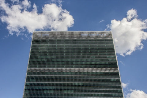 UN Building - close-up on top of United Nations from front - isolated on blue sky with clouds on beautiful sunny summer day