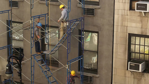 construction workers on building scaffolding in hardhats in NYC