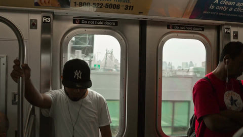 man with Yankee hat riding subway in Queens NYC