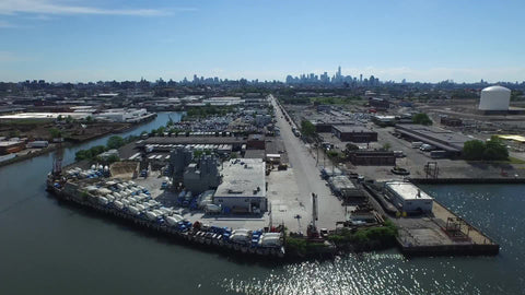 aerial waterfront where Brooklyn meets Queens - Manhattan skyline in far distance in NYC