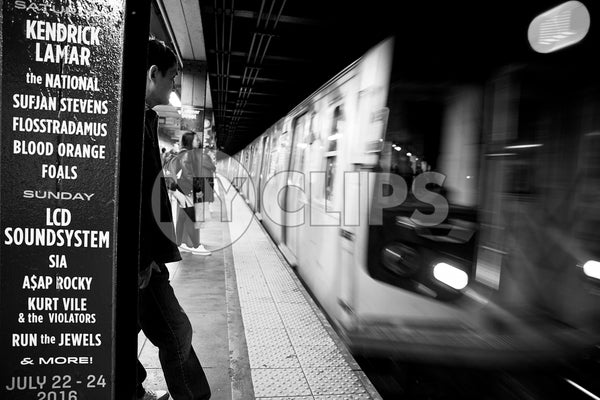 man waiting for subway train entering platform in NYC