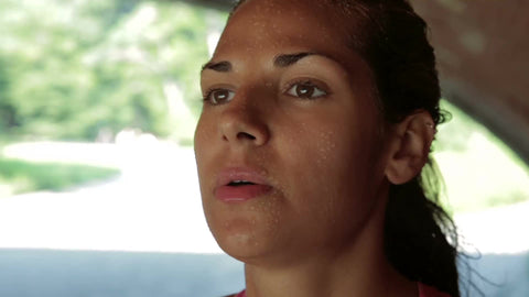 tight shot of woman's face sweating and breathing heavy after exercise - jogger catching breath in Central Park