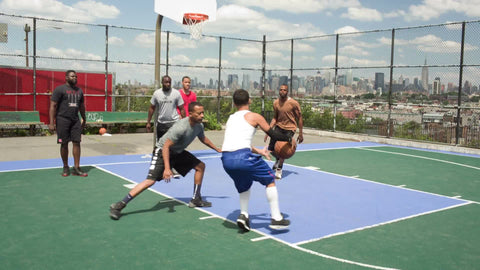 kid makes jump-shot on basketball court in New Jersey with view of Manhattan skyline in NYC on hot summer day