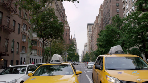 Lower 5th Ave with Taxi cabs lined up at crosswalk light - 4K in slow motion Manhattan New York City
