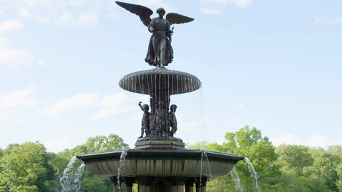 Bethesda Statue in Central Park with water fountain flowing on beautiful day - winged angel sculpture in 4K NYC