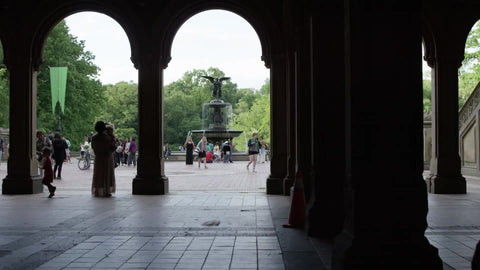 silhouette of family under Bethesda Terrace in Central Park with statue in background