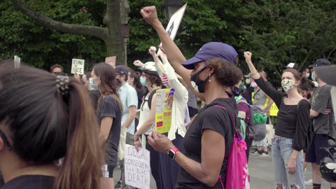 Black woman holding up fist at BLM rally in Washington Square Park New York City