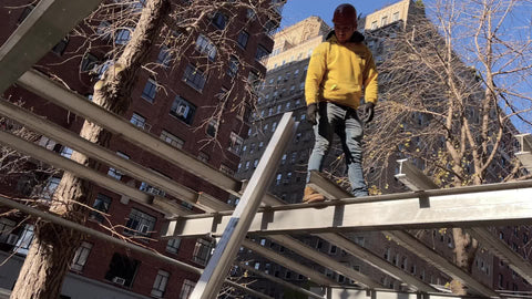 construction worker high up on scaffolding beam building carrying metal New York City NYC