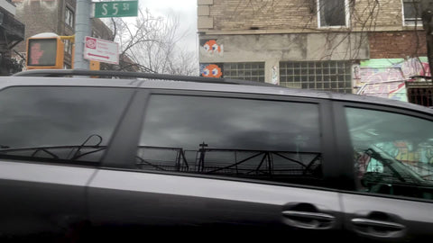 driving past colorful art mural in Brooklyn with snow on cars in winter New York City NYC