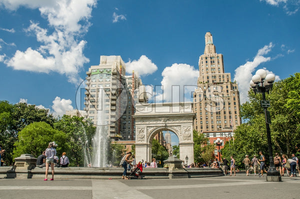 Washington Square Park in summer with fountain spraying water and famous arch, people enjoying beautiful weather