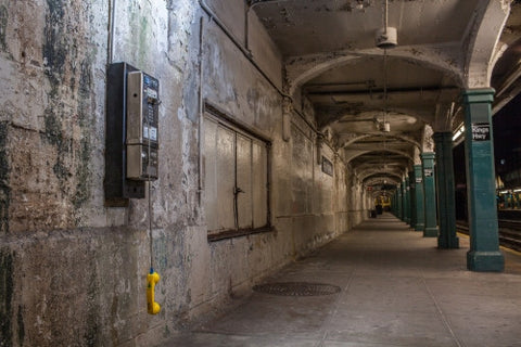 payphone dangling in Kings Highway train station in Brooklyn - gritty subway platform