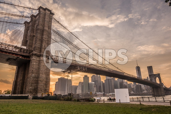 Brooklyn Bridge and Manhattan skyline during the day - beautiful orange sky at sunset in NYC