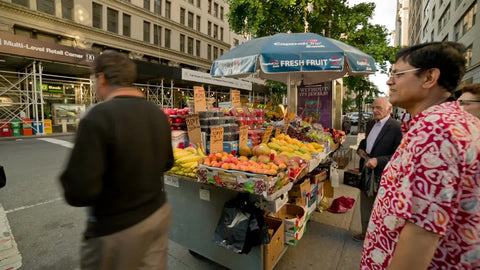 woman reaching for fresh berries - street vendor selling fruit in summer