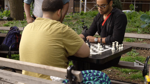 racial diversity in Washington Square Park - people playing chess at tables in 4K slow motion New York City