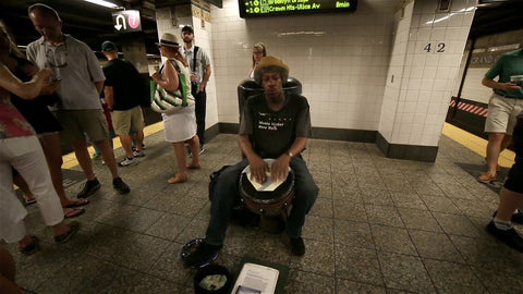 drummer playing conga drum on subway station platform in summer