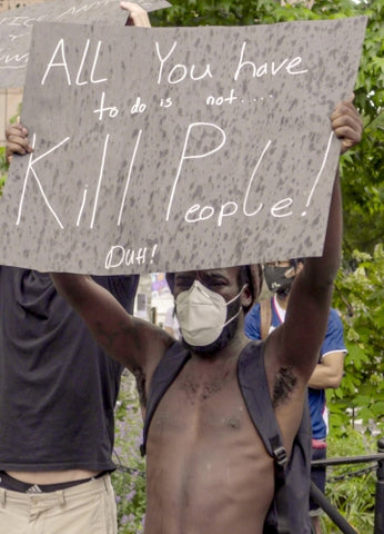 man holding sign at Black Lives Matter rally in NYC