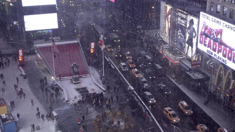 panning across snowing in Times Square from window above on high floor - winter in 4K and 1080 HD in NYC