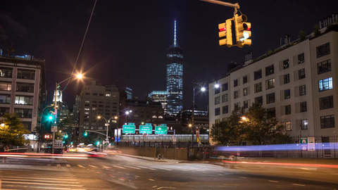 slow zooming out from Freedom Tower at night with signs for Brooklyn and Hudson Street - 4K timelapse in Downtown Manhattan NYC