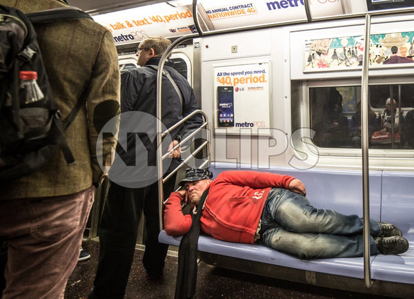 homeless man sleeping on subway train seats, taking up whole bench