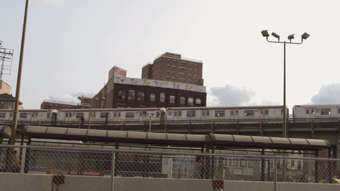 subway train on elevated track and MTA public bus driving in Brooklyn during day