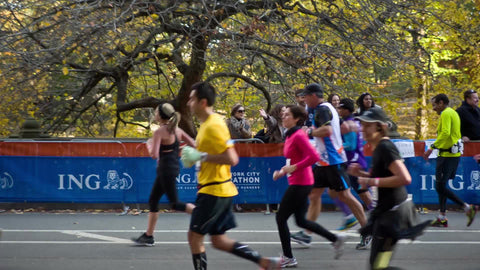 marathon runners finishing final mile in Central Park from side view with spectators onlooking in NYC