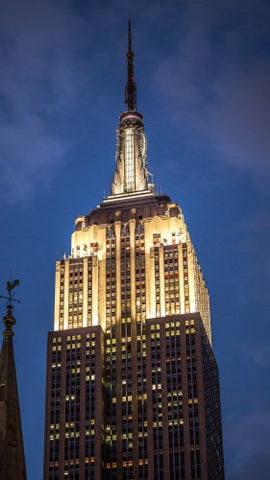 Empire State Building famous landmark skyscraper at night with lights on in Manhattan