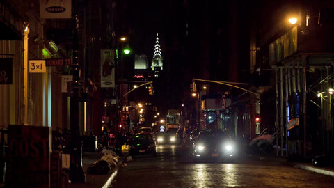 SoHo street at night with Chrysler Building lights in background in NYC