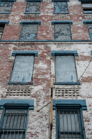 gritty boarded up abandoned tenement building in ghetto