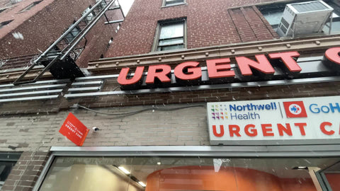 Urgent Care emergency medical clinic sign panning left to right overhead snowing raining winter New York City NYC