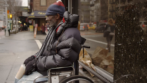 disabled homeless man in wheelchair shaking cup on cold winter day - 4k in slow motion on Manhattan street in NYC
