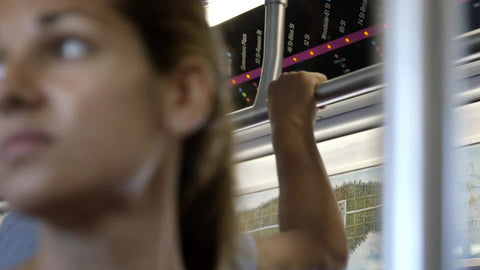 close-up on beautiful woman's face, riding 7 Train - standing on crowded subway with passengers