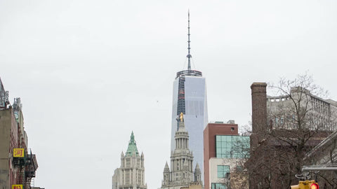 tilting down from closeup of Freedom Tower to Chinatown street in fall