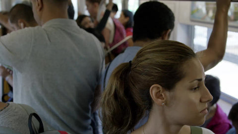 crowded subway train, woman with ponytail standing with other passengers
