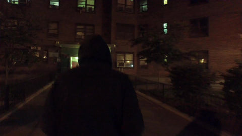 unidentified man with black hoodie walking at night into housing project in NYC