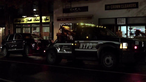 NYPD tow truck driving away with parked car - towing at night