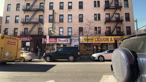 driving up Amsterdam Avenue above 125th street liquor and wine stores shops in Harlem New York City NYC