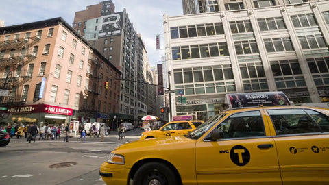 taxis driving in Midtown traffic on sunny day