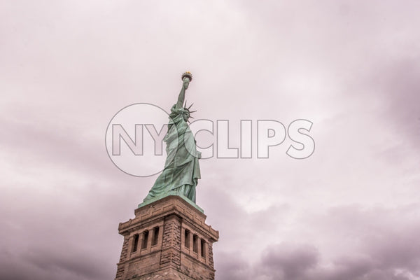 Statue of Liberty - full shot head to toe with base over pink cloudy sky
