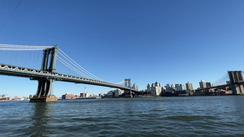 Manhattan Bridge to Brooklyn Bridge panning across East River from South Street Seaport New York City NYC