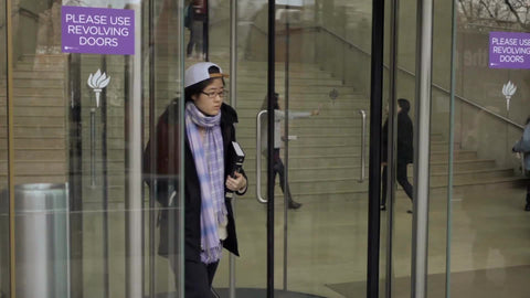 NYU revolving door, student exiting New York University building