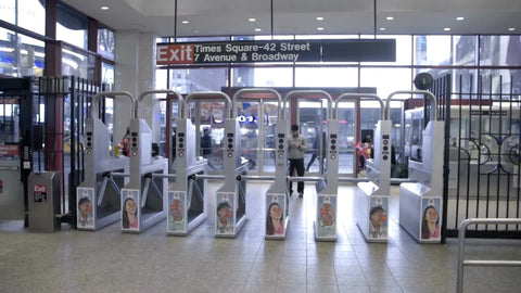 interior Times Square subway station - panning from turnstiles to escalator at night in slow motion